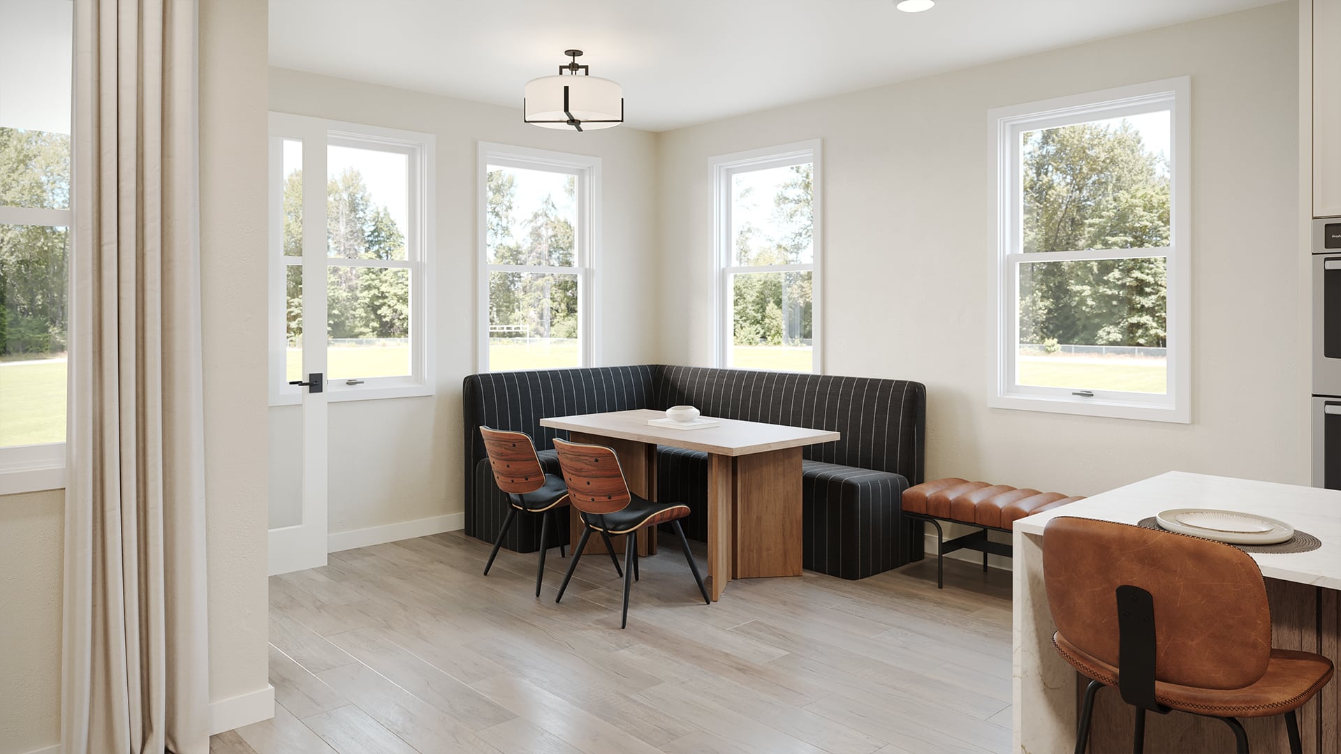 Cozy dining nook with a wood table, L-shaped pinstriped bench, two wooden chairs, leather bench, and large windows.