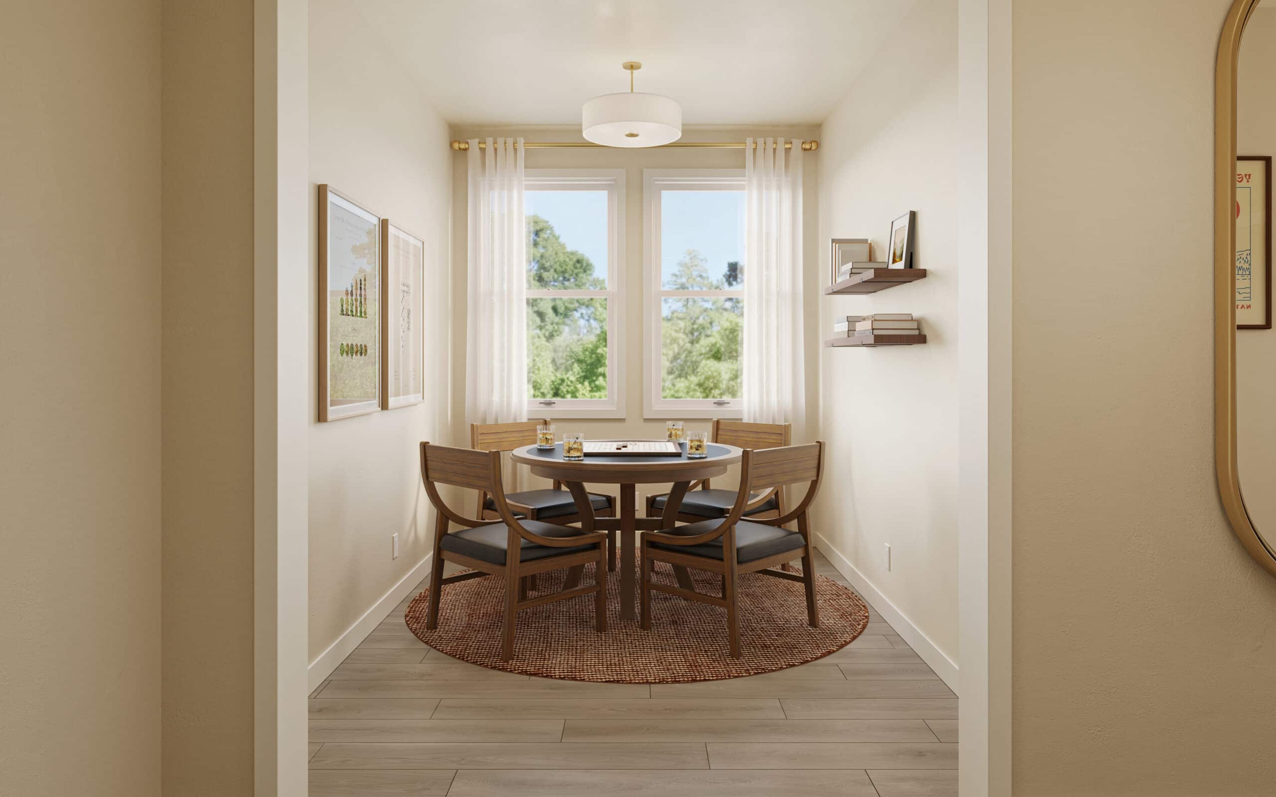 Bright dining nook with a round wooden table, four chairs, wall shelves, framed art, and windows overlooking trees